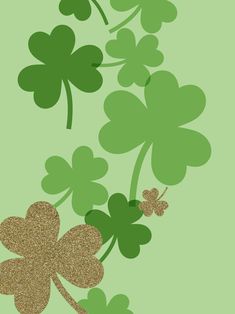 four leaf clovers on a green background with gold glitter in the shape of hearts