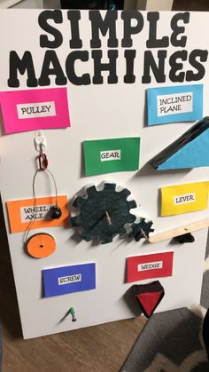 a sign that says simple machines and has various pieces of paper attached to the board