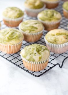 cupcakes with green frosting sitting on a cooling rack