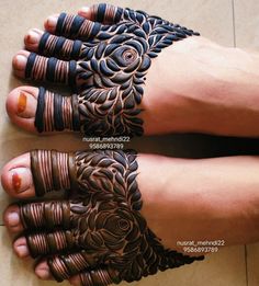 two feet with hendi designs on them, one is brown and the other is black