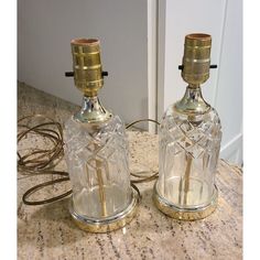 two clear glass candlesticks sitting on top of a counter next to each other