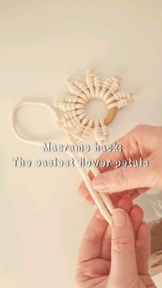 a person is holding a rope with a flower on it and the words macrami hack