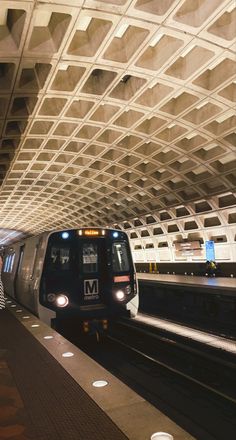 a subway train pulling into the station with its lights on