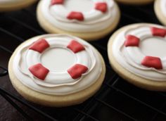 cookies decorated with red and white icing on a cooling rack