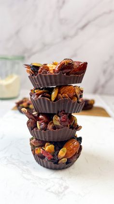 three chocolate cups stacked on top of each other with nuts and raisins in them