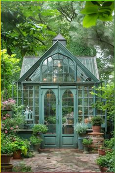 a green house with potted plants in the front and side windows on either side