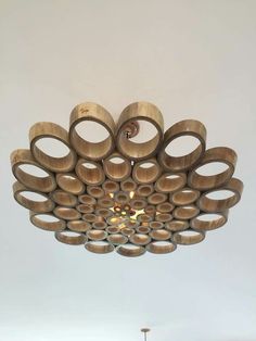 a chandelier made out of wooden circles hanging from the ceiling