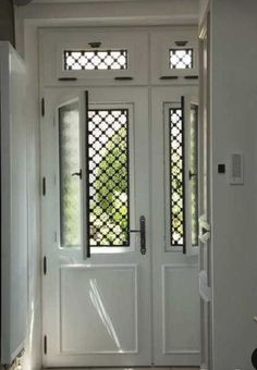 a white front door with two sidelights and glass panels on the top, in an entryway