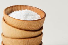 three wooden bowls stacked on top of each other with sugar in them and one is empty