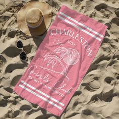 a towel and hat laying on the sand