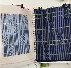 an open book with blue and green designs on the pages, next to a notebook