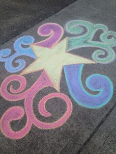 a chalk drawing of a star and swirls on the sidewalk