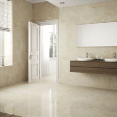 an empty bathroom with two sinks and a large mirror on the wall next to it