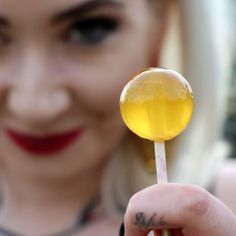 a close up of a person holding a lollipop