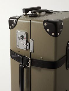 a suitcase with black handles and white polka dots on the handle is shown in front of a white background