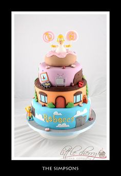 a three tiered cake with cartoon characters on it's top and bottom layer