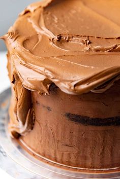 a chocolate frosted cake sitting on top of a glass plate