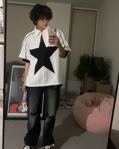 a person taking a selfie in a mirror with a black star on the shirt