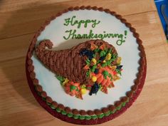 a decorated thanksgiving cake sitting on top of a wooden table