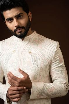 Ivory sherwani with mandarin collar, full sleeves, all over vintage pattern ekhtar resham embroidery and sequin work. Paired with silk kurta and cotton pyjama.
Components: 3
Pattern: Embroidered
Type Of Work: Ekhtar Resham and Sequin Work
Neckline: Mandarin Collar
Sleeve Type: Full Sleeves
Fabric: Sherwani: heavy Modal, Kurta: Silk, Pyjama: Cotton
Color: Beige
Other Details: 
Front concealed placket
Back placement embroidery
Front and side slits
Occasion: Groom,Wedding - Aza Fashions Designer Cream Nehru Jacket With Long Sleeves, Designer Cream Sherwani With Long Sleeves, Designer Cream Fitted Kurta, Designer Cream Long Sleeve Sherwani, Designer Long Sleeve Cream Sherwani, Designer Cream Kurta For Transitional Season, Ceremonial Cream Long Sleeve Kurta, Ceremonial Long Sleeve Cream Kurta, Cream Long Sleeve Bandhgala For Eid