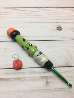 a green and black toothbrush sitting on top of a wooden table next to a keychain