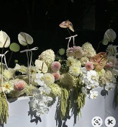 an arrangement of white and pink flowers on display