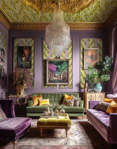 a living room filled with purple couches and paintings on the wall next to a chandelier