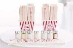 some popcorn sticks sitting on top of a white cake plate with red and white stripes