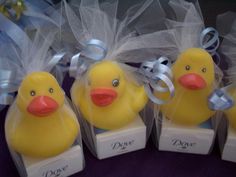 four yellow rubber ducks with tulle bows on their heads, sitting in small boxes