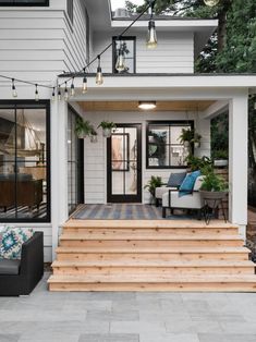 an outdoor patio with steps leading up to the front door and seating area on either side