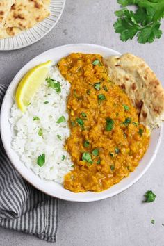 two plates with rice, curry and pita bread