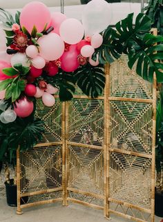 the balloon arch is decorated with pink, white and green balloons for a tropical wedding