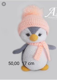 a crocheted penguin wearing a pink hat and scarf