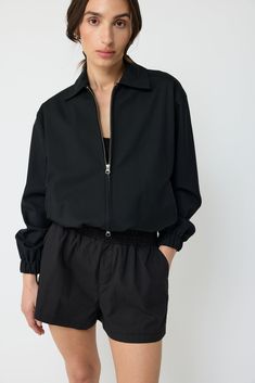 The wool bomber jacket features a slight oversized silhouette crafted of a lightweight wool fabric. Relaxed dropped-shoulder sleeves and a bubble hem define the look. It has a spread collar with ribbed cuff sleeves. Pair it back to the midi skirt or cargo trousers. Bubble Hem, Silhouette Crafts, Oversized Silhouette, Cargo Trousers, Wool Fabric, Cuff Sleeves, Jewelry Sales, Jumpsuit Dress, Midi Skirt