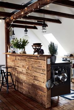 a kitchen with an island made out of wooden planks and potted plants on top