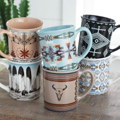 four coffee mugs sitting on top of a wooden table