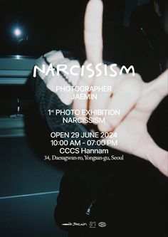 a person making the peace sign in front of a poster for an art exhibition on photography