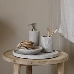 a wooden table topped with a soap dispenser and brush