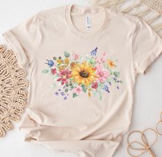 a t - shirt with sunflowers and butterflies on it next to some doily