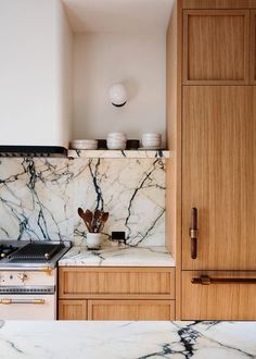 a kitchen with marble counter tops and wooden cabinetry in the backround area