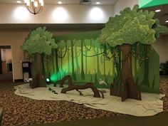 an indoor play area with fake trees and animals