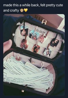 a person holding an open suitcase filled with pictures and letters on it's lid