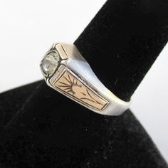 A vintage ring marked "10K ON STERLING".  It's all sterling silver with gold panel accent on the shoulders.  Noticeable vintage wear and some darkness.  It also has a colorless stone center.  A size 9 on my ring sizer. Please check out my store with similar things added almost daily. Remember, shipping for additional items is always free. Vintage Sterling Silver Signet Ring With Gemstone, Vintage Gold-colored Sterling Silver Signet Ring, Vintage Adjustable Signet Ring, Tarnish Resistant, Nickel-free Vintage Sterling Silver Signet Ring, Vintage Sterling Silver Engraved Ring, Hallmarked, Ring Sizer, Vintage Ring, Vintage Wear, Solitaire Ring