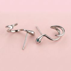 These fun sterling silver snake wrap stud earrings add a touch of whimsy to your day. The solid 925 sterling silver snakes are highly polished for a great shine, and plated in platinum or gold for an eye-catching finish. The snakes wrap around themselves in twisty cuffs, providing a unique and amusing option for everyday wear or as a gift to brighten someone's day. The snake wrap stud earrings make a fun addition to your fine jewelry collection or as a gift for a loved one who appreciates humoro Silver Ear Climbers Fine Jewelry Gift, Silver Fine Jewelry Ear Climbers As Gift, Silver Snake Shape Metal Earrings, Silver Snake Shaped Metal Earrings, Silver Snake-shaped Metal Earrings, Trendy Silver Snake-shaped Jewelry, Silver Snake-shaped Earrings, Silver Metal Ear Climbers As Gift, Silver Snake-shaped Single Earring