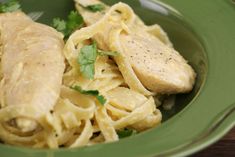 pasta with chicken and parsley in a green bowl