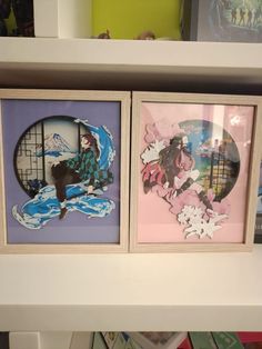 three framed pictures on a shelf in a room