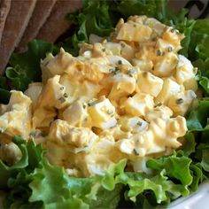 a salad with cheese and lettuce in a white bowl