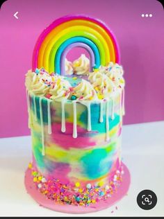 a rainbow cake with white frosting and sprinkles