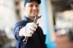 a man holding a wrench in his right hand