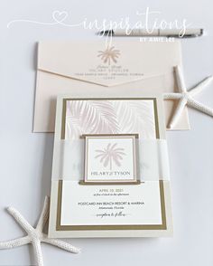 the wedding stationery is set on top of an envelope and some starfishs